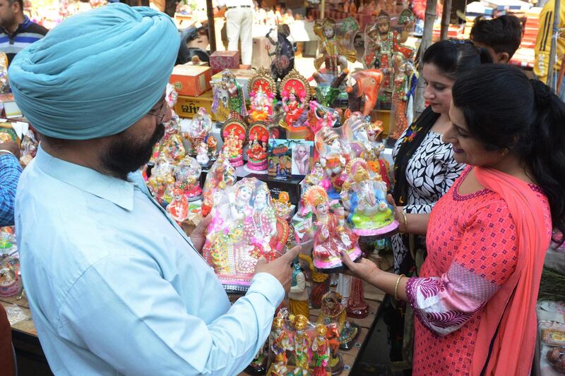 Indian shoppers look for idols of Hindu goddess Laxmi and Lord Ganesh on the eve of the Hindu festival of "Diwali", in Amritsar on November 6, 2018. "Diwali", the Festival of Lights, marks victory over evil and commemorates the time when Hindu god Lord Rama achieved victory over Ravana and returned to his kingdom Ayodhya / AFP / NARINDER NANU
