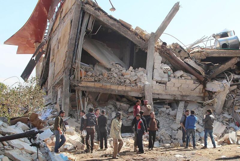 People gather around the rubble of a hospital supported by Doctors Without Borders (MSF) near Maaret Al Numan, in Syria's northern province of Idlib, on Febrary 15, 2016, after the building was hit by suspected Russian air strikes. MSF confirmed that a hospital supported by the aid group in Idlib province was 'destroyed in air strikes'. Ghaith Omran/AFP
