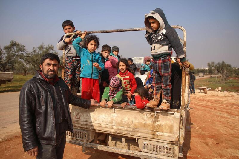 Displaced Mustafa Haj Ahmad poses for a picture with his children and relatives in a newly-established camp on the edges of Maaret Misreen town in Syria's Idlib province.  AFP