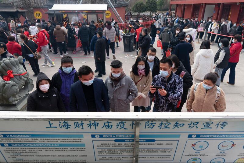 People read a notice on COVID-19 regulations as they gather to pray at a temple in Shanghai, China. Today marks the fifth day of Spring Festival celebrations in China. Getty Images