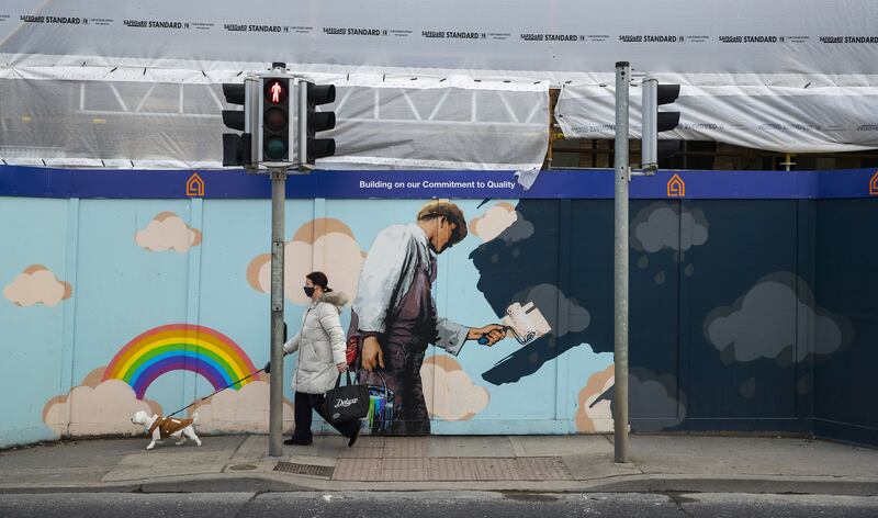A woman walking past a mental health related mural in Dublin on February 24, 2021.
