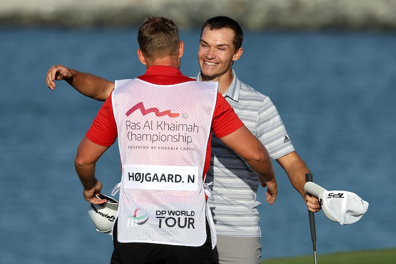 Nicolai Hojgaard celebrates with his caddie at the Al Hamra Golf Club. Getty