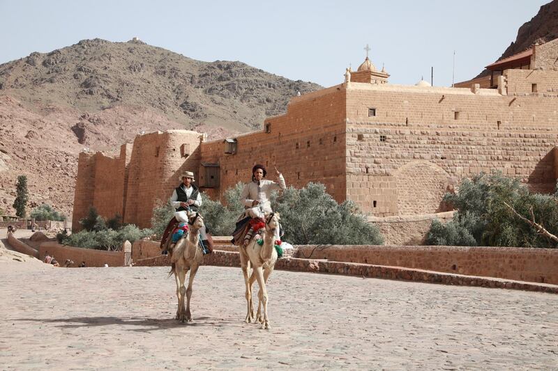 Bedouin men ride camels in front of Saint Catherine's monastery, near Saint Catherine, South Sinai, Egypt. The country is trying to boost its tourism sector, which has been hit hard by the Covid-19 pandemic. EPA