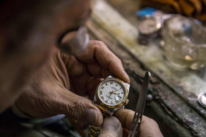 Samy Taha repairs a watch at Francis Papazian. The shop is found under the arcade of an old Haussmann-style building in central Cairo and is currently surrounded by street sellers. AFP