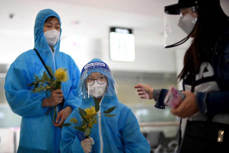 Travellers from Vietnam wearing personal protective equipment at Sydney's international airport following their arrival. AFP
