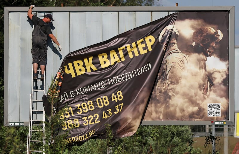 On the outskirts of Saint Petersburg, a banner promoting the Wagner private mercenary group is taken down from view. Reuters