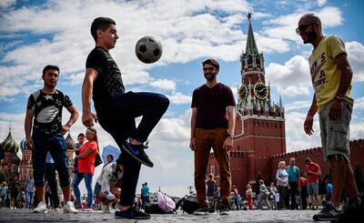 Men play with a ball on Red Square near the Kremlin in downtown Moscow on July 13, 2018, two days before the Russia 2018 World Cup final football match between France and Croatia.  / AFP / Alexander NEMENOV
