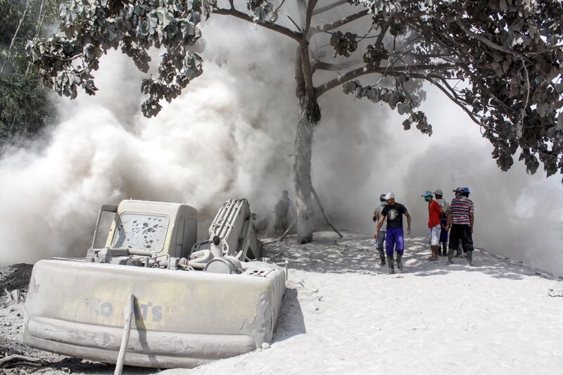 People are seen on road blanketed with volcanic ash from the erupting Mount Semeru in Lumajang, East Java Province, Indonesia. Reuters