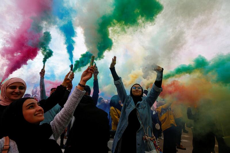 Iraqi women wave colored smoke candles during the festival of colors, in the holy Shi'ite city of Najaf, Iraq January 15, 2020. Reuters