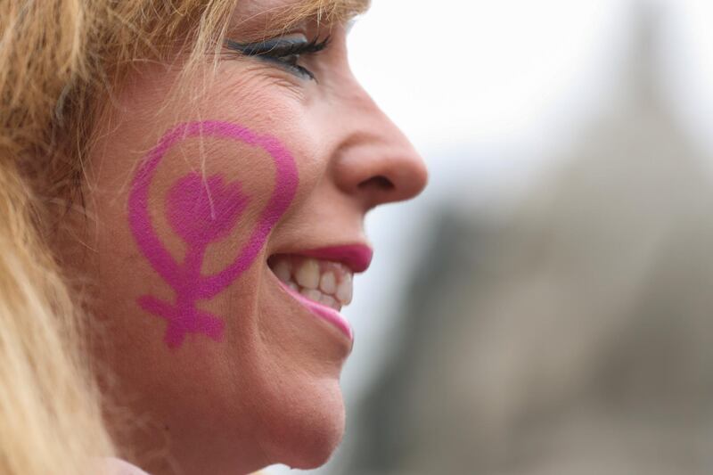 A woman smiles at a nationwide feminist strike on International Women's Day at Cibeles Square in Madrid, Spain, March 8, 2018. REUTERS/Sergio Perez