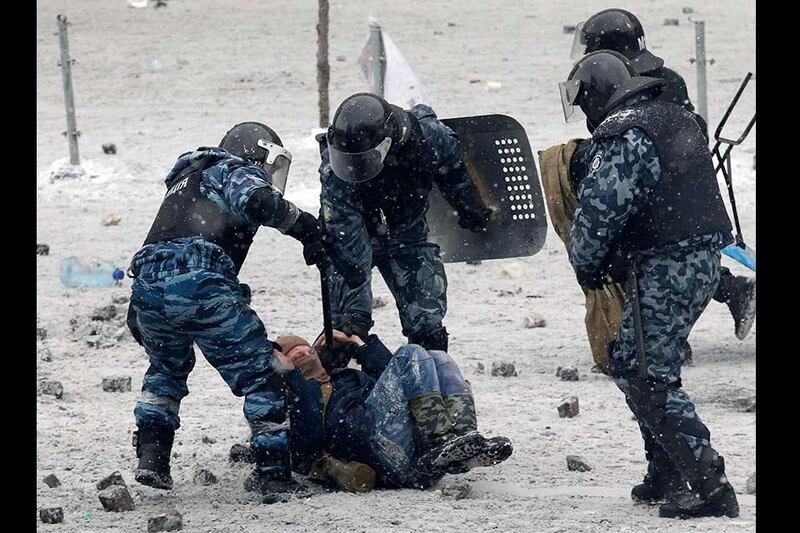 Riot police officers hold a man lying on the ground during clashes between police and pro-European protesters in Kiev January 22, 2014. Ukrainian President Viktor Yanukovich has agreed to meet the three main opposition leaders on Wednesday for talks on a crisis that has led to violent clashes between protesters and police, said one of the leaders, Arseny Yatsenyuk. REUTERS/Vasily Fedosenko (UKRAINE - Tags: POLITICS CIVIL UNREST)