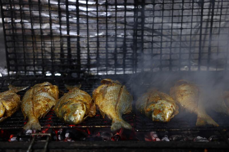 Fresh fish is grilled on charcoal before being served to customers at Roma fish restaurant owned by the Abu Hassira family in Gaza city.
