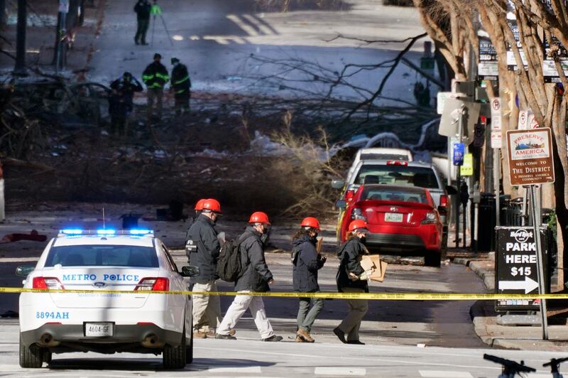 Investigators walk near the scene of an explosion  in Nashville, Tenn. The explosion that shook the largely deserted streets of downtown Nashville early Christmas morning shattered windows, damaged buildings and left several people wounded. Authorities said they believed the blast was intentional. AP