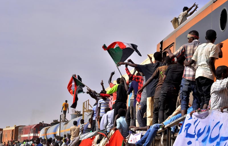Sudanese demonstrators attending a sit-in protest, stand on a train as they block it from passing through, outside the Defence Ministry in Khartoum. Reuters