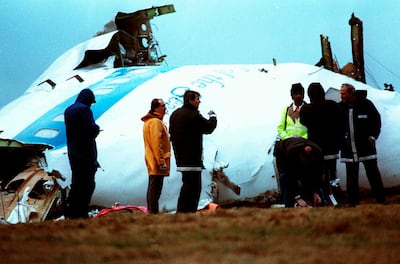 Unidentified crash investigators inspect the nose section of the crashed Pan Am flight 103, a Boeing 747 airliner in a field near Lockerbie, Scotland, Dec.  23, 1988. AP