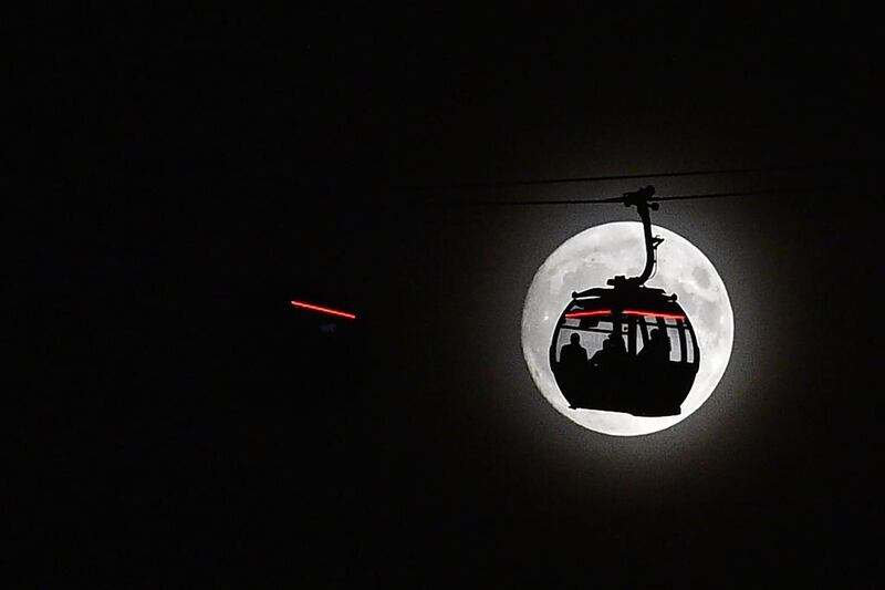 The supermoon rises behind a cable car on The Emirates Air Line in London’s Docklands. Glyn Kirk / AFP