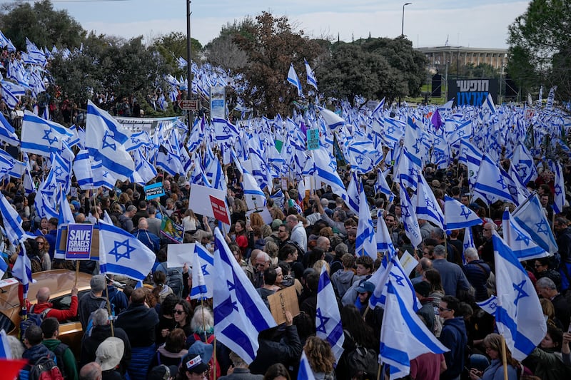 Israelis wave national flags at the rally in Jerusalem. AP