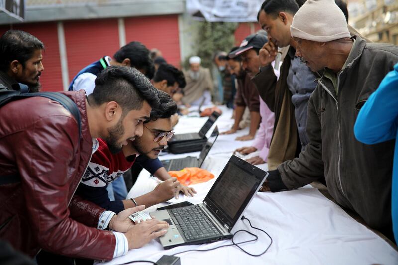 Political party agents help voters find their serial number and voting center during the general election in Dhaka. Reuters