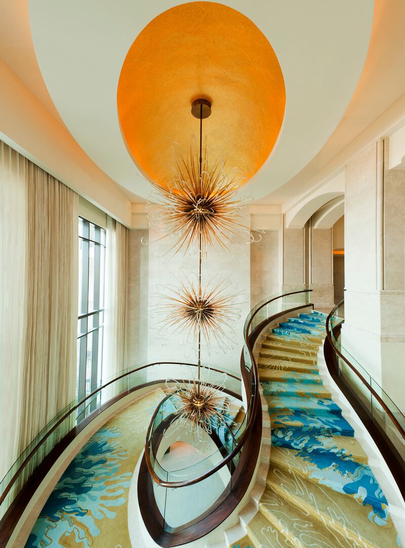 Descend the flowing staircase from the hotel lobby.