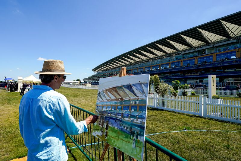 An artist painting a scene at the racecourse. Getty Images