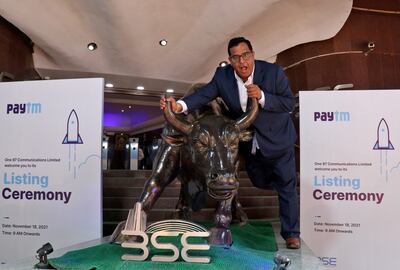 Paytm founder and chief executive Vijay Shekhar Sharma poses with a bronze replica of a bull after the company's IPO listing ceremony at the Bombay Stock Exchange in Mumbai, on November 18, 2021.  Reuters