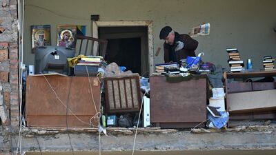 A resident throws away damaged items as he retrieves what he can from his destroyed apartment in Kyiv.  AFP