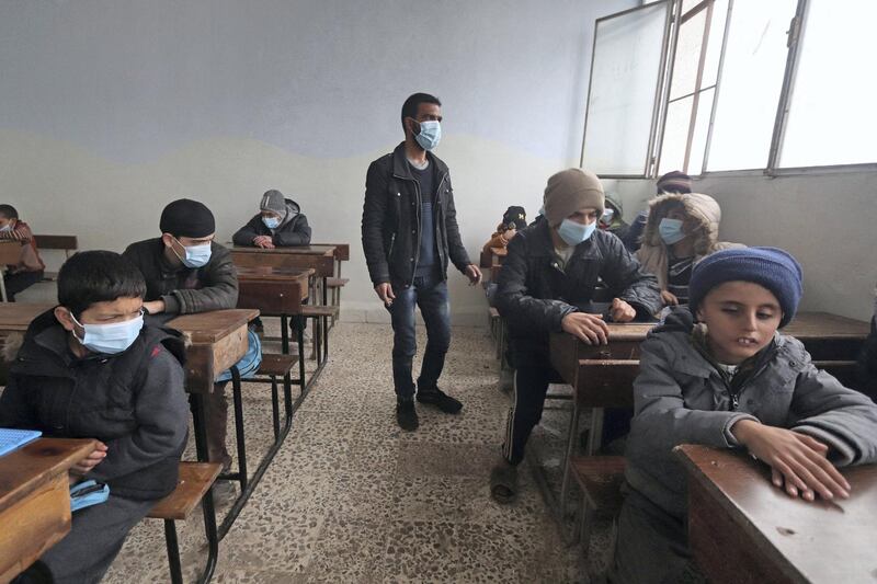 A blind Syrian teacher leads visually impaired pupils during a lesson, respecting social distancing amid the spread of the coronavirus disease (COVID-19), at a school for the blind in the rebel-held northwestern city of Idlib on December 20, 2020. (Photo by Ahmad al-ATRASH / AFP)