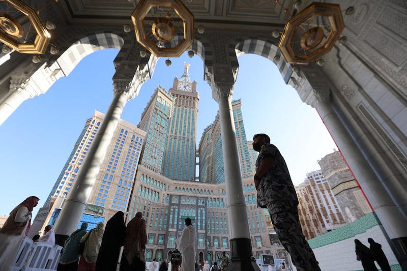 A member of the Saudi security forces stands on duty at an entrance to the Grand Mosque of Makkah ahead of Ramadan, with the holy city's Clock Tower in the background.  AFP