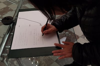 People sign a book of condolence for former French President Jacques Chirac at The Elysee Palace in Paris late September 26, 2019, after his death at the age of 86.  Former French president Jacques Chirac died at the age of 86 after a long battle with deteriorating health, prompting tributes from across the political spectrum for a charismatic statesman who famously said "non" to the 2003 Iraq war. / AFP / Laurence BENHAMOU
