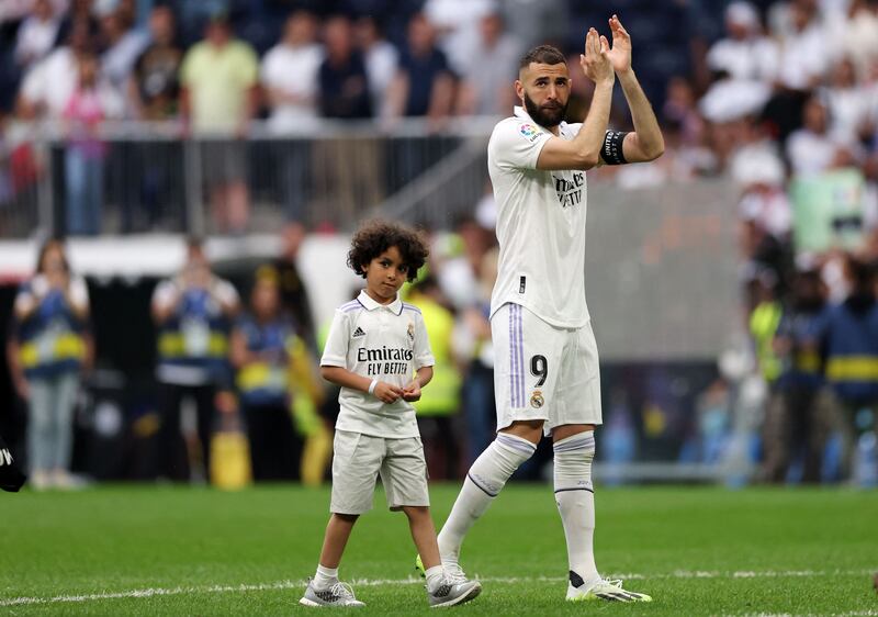 Real Madrid's French forward Karim Benzema applauds next to his son. AFP