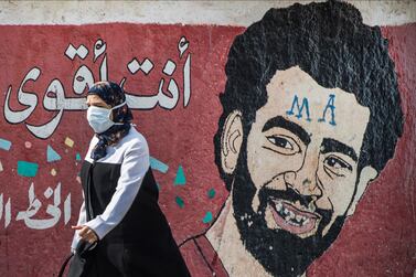 A woman wearing a protective mask walks in front of a mural depicting Liverpool's Egyptian striker Mohamed Salah in Cairo, Egypt, 25 March 2020. Egyptian authorities announced a two-week curfew, starting from 25 March, during which public transportation will be suspended to avoid the spread of coronavirus. EPA