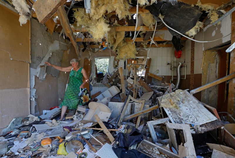 A Ukrainian woman walks through the destroyed home of her son, who was killed the day before by shelling in Donetsk. Reuters