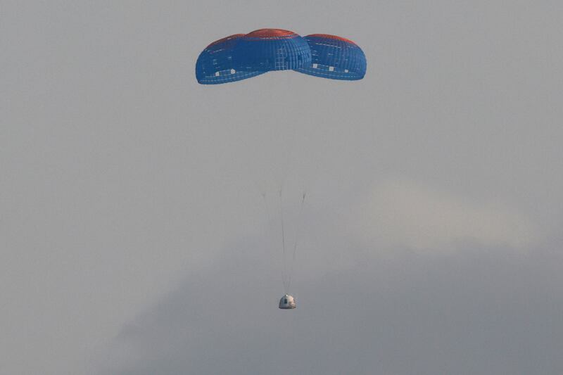 The capsule carrying  Jeff Bezos and three crew members returns to Texas by parachute.
