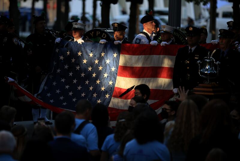 Members of the New York Police and Fire Department hold a flag for the national anthem during the annual 9/11 Commemoration Ceremony at the National 9/11 Memorial and Museum in New York City.  AFP