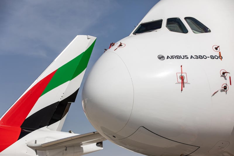 The logo of Emirates Airline sits on the tailfin of a Boeing Co. 777-300 aircraft, parked near an Airbus SE A380-800 aircraft on the first day of the 16th Dubai Air Show at Dubai World Central (DWC) in Dubai, United Arab Emirates, on Sunday, Nov. 17, 2019. The Dubai Air Show is the biggest aerospace event in the Middle East, Asia and Africa and runs Nov. 17 - 21. Photographer: Christopher Pike/Bloomberg