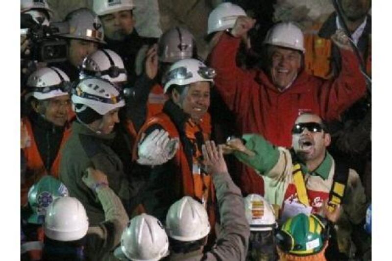 The Chilean president, Sebastian Pinera, top right, cheers as Mario Sepulveda Espina, with sunglasses, salutes after being rescued.