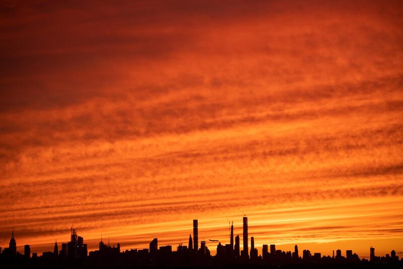 A plane flies over Manhattan's skyline at sunset in New York City. AFP
