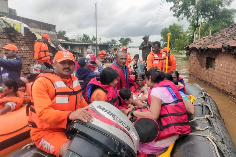 NDRF personnel rescue people stranded in flood waters on the outskirts of Sangli. NDRF / AFP