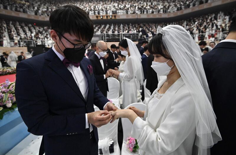 Couples wearing protective face masks attend a mass wedding ceremony organised by the Unification Church at Cheongshim Peace World Center in Gapyeong.  AFP