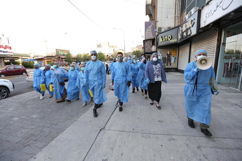 Iraqi medical specialists take part in a testing process for the coronavirus in Baghdad's Karada district. EPA