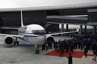 In this Dec. 15, 2018, photo, invited guests look at the Boeing 737 Max 8 airplane parked on tarmac after being delivered to Air China at Boeing Zhoushan 737 Completion and Delivery Center in Zhoushan, east China's Zhejiang Province. China's civilian aviation authority has ordered all Chinese airlines to ground their Boeing 737 Max 8 planes on Monday, March 11, 2019 after one of the aircraft crashed in Ethiopia. The authority said the one-day action was made out of safety concerns because the crash was similar to one in Indonesia last year. (Chinatopix via AP)
