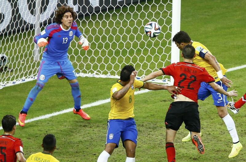 Brazil's Thiago Silva, right, heads the ball but fails to get it past Mexico's Guillermo Ochoa, left, during their 2014 World Cup Group A soccer match at the Castelao Arena in Fortaleza on June 17, 2014. Mike Blake / REUTERS