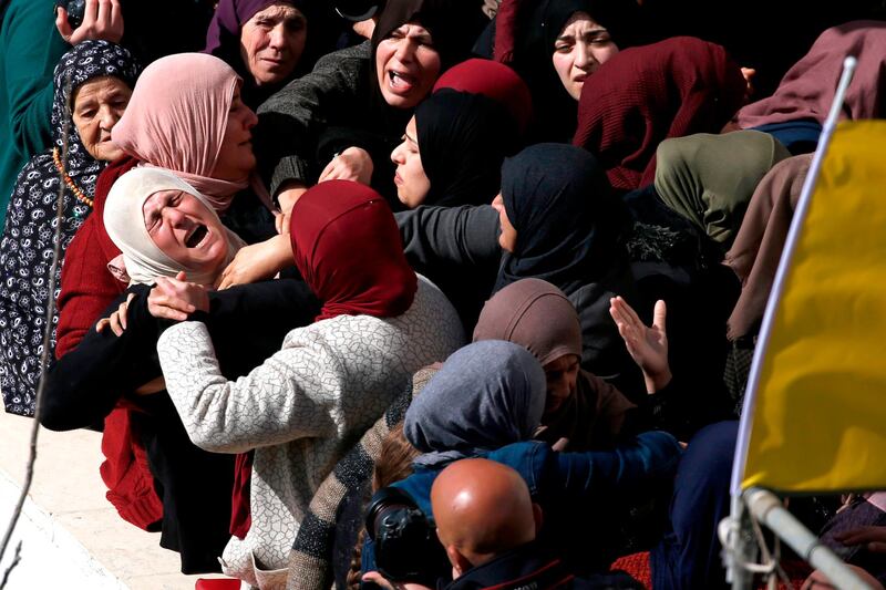 TOPSHOT - The mother (L) of 17-year-old Palestinian Ayman Hamed, who was fatally shot by Israeli troops a day earlier while throwing stones at Israeli motorists, mourns during his funeral in the village of Silwad, 15 kilometres northeast of Ramallah in the occupied West Bank, on January 26, 2019. Another Palestinian was injured alongside Hamed, the Israeli army said, as soldiers "responded by firing at the suspects, who received medical treatment. One of the suspects later died of his wounds and another was injured." The army added that it was investigating the incident. / AFP / ABBAS MOMANI
