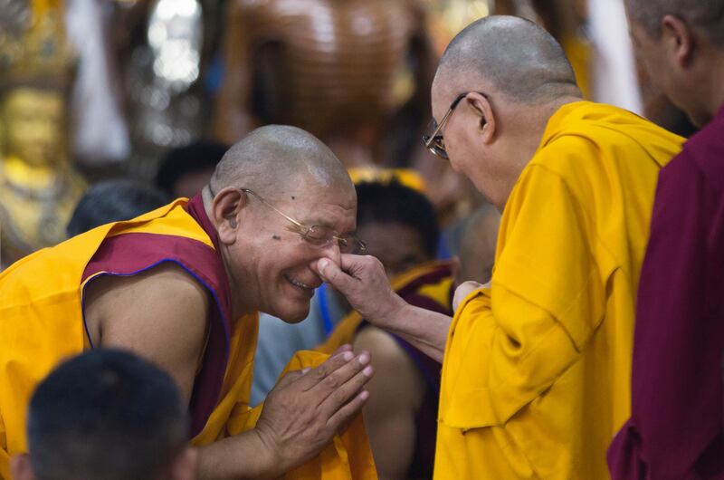 The Dalai Lama pinches the nose of a senior monk as he arrives to give a talk to Tibetan youth in Dharmsala, India. Ashwini Bhatia / AP Photo