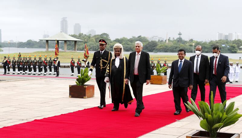 Mr Wickremesinghe, centre, arrives at his swearing-in ceremony in Colombo. EPA