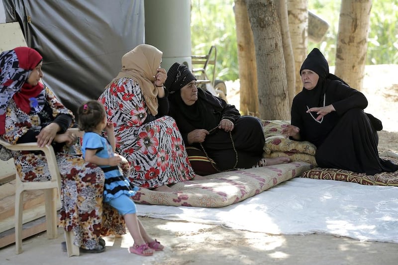 Syrian refugee women sit on mats talking at an unofficial camp for refugees in the village of Bar Elias in the Bekaa Valley in central Lebanon (AFP PHOTO / JOSEPH EID)