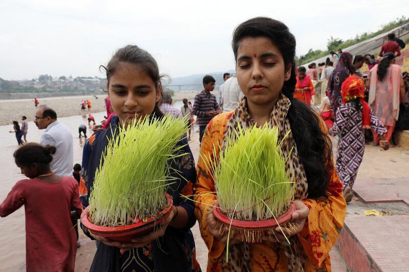 epa07903488 Indian Hindu devotees prepare to releases bowls with 'Saakh' representing the Goddess Durga into the Tawi River on the last day of Navratri in Jammu, the winter capital of Kashmir, India, 07 October 2019. The Navratri festival is dedicated to the Hindu Goddess Durga and is celebrated twice a year, once during the spring and once in autumn.  EPA/JAIPAL SINGH