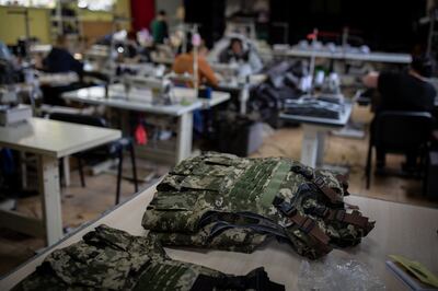  A pile of freshly made military vests sit on a table in a makeshift factory in Mykolaiv. All the material is sourced locally in markets or through donations. Oliver Marsden for The National