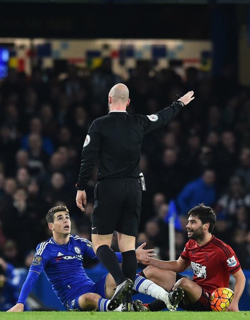 Chelsea’s Brazilian midfielder Oscar (L) and West Bromwich Albion’s Argentinian midfielder Claudio Yacob (R) react as referee Anthony Taylor gestures during the English Premier League football match between Chelsea and West Bromwich Albion at Stamford Bridge in London on January 13, 2016. The game finished 2-2. AFP PHOTO / BEN STANSALL