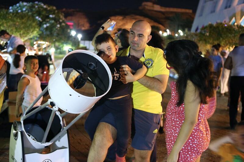 A young boy looks at the stars through a telescope in Al Ain. Pawan Singh / The National